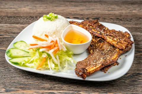Caramelised grilled pork with rice, pickled salad and dipping sauce