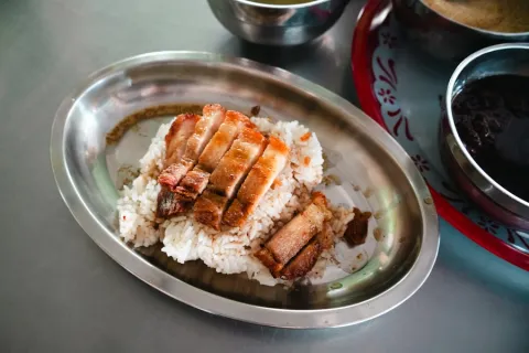 Sliced crispy pork belly over steamed rice