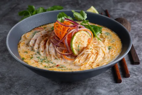 Coconut laksa with chicken, vermicelli, carrot and lime