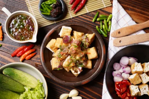 Fried tofu topped with chilli and herbs in a claypot