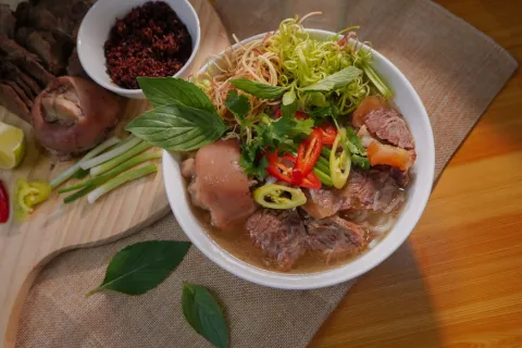 Spicy Hue beef noodle soup with pork hock, chilli and herbs